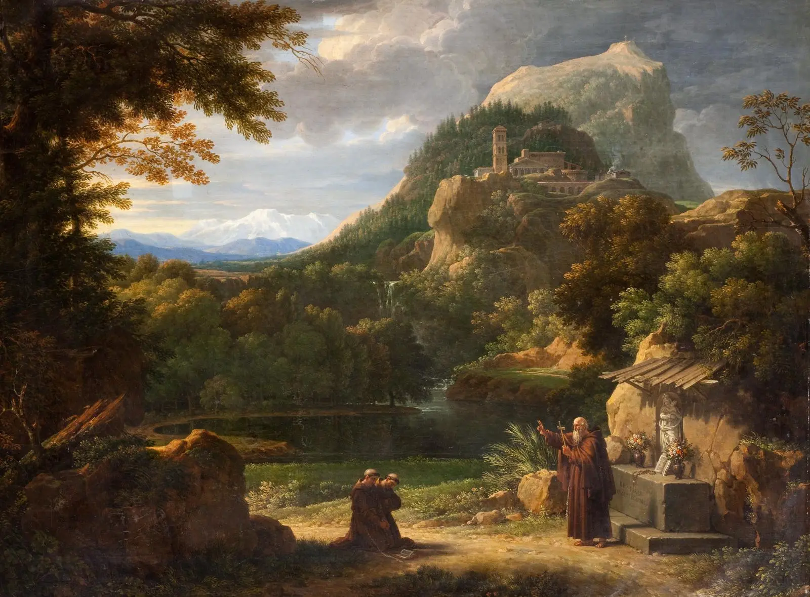 Tableau de François-Xavier Fabre montrant, dans un paysage montagneux avec un bâtiment sur un promontoire, une sascade et un lac, un moine âgé (sain Antoine de Padoue), sur la droite, se tient debout en tenant une croix dans sa main gauche et tend le bras droit. En face de lui, deux moines agenouillés.