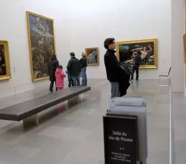 Vue de la salle du jeu de paume ; des visiteurs regardent les tableaux.